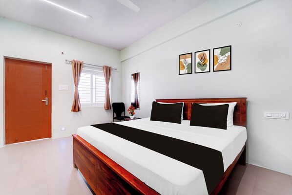 A bedroom with a wooden bed, white walls, and a window with curtains.