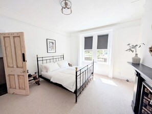 A bedroom with a bed, a door, a window, a picture on the wall, and a vase with plants. - The Farlan | Near North Shields Fish Quay (North Shields)