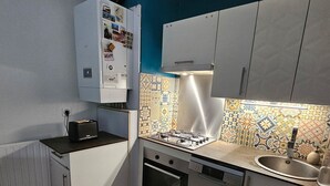 A compact kitchen with a gas stove, oven, dishwasher, and a refrigerator. - L'amirauté pour 4 personnes (La Rochelle)
