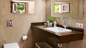 A bathroom with a toilet, sink, mirror, and a small window. - Hillside Villa With Pool for 5 (Pollença)