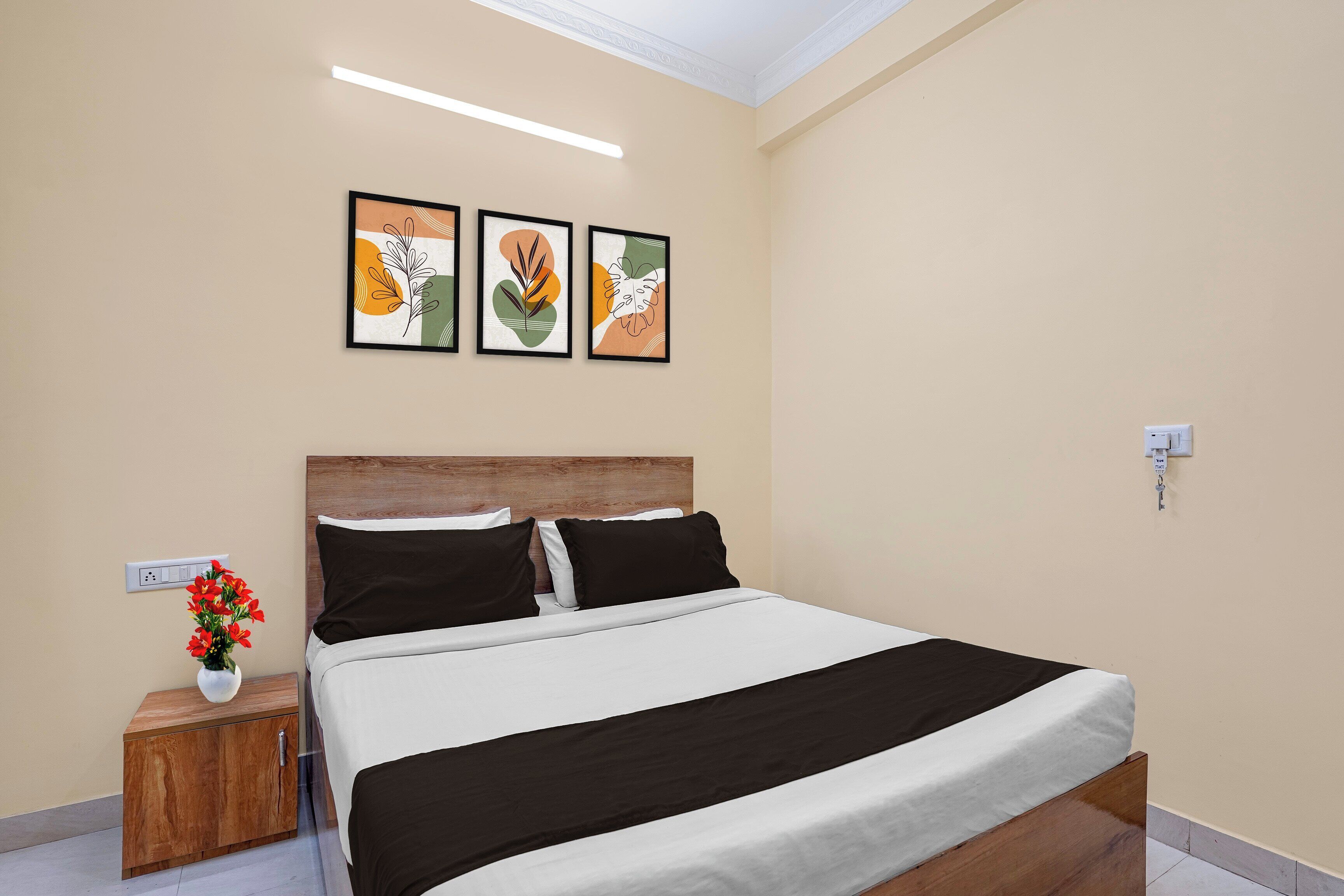 A bedroom with a bed, bedside table, and a wall-mounted power outlet.