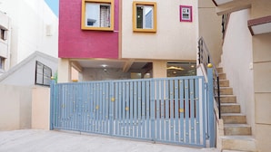 Un edificio residencial con una puerta azul, una escalera y un ventanal con marco amarillo.