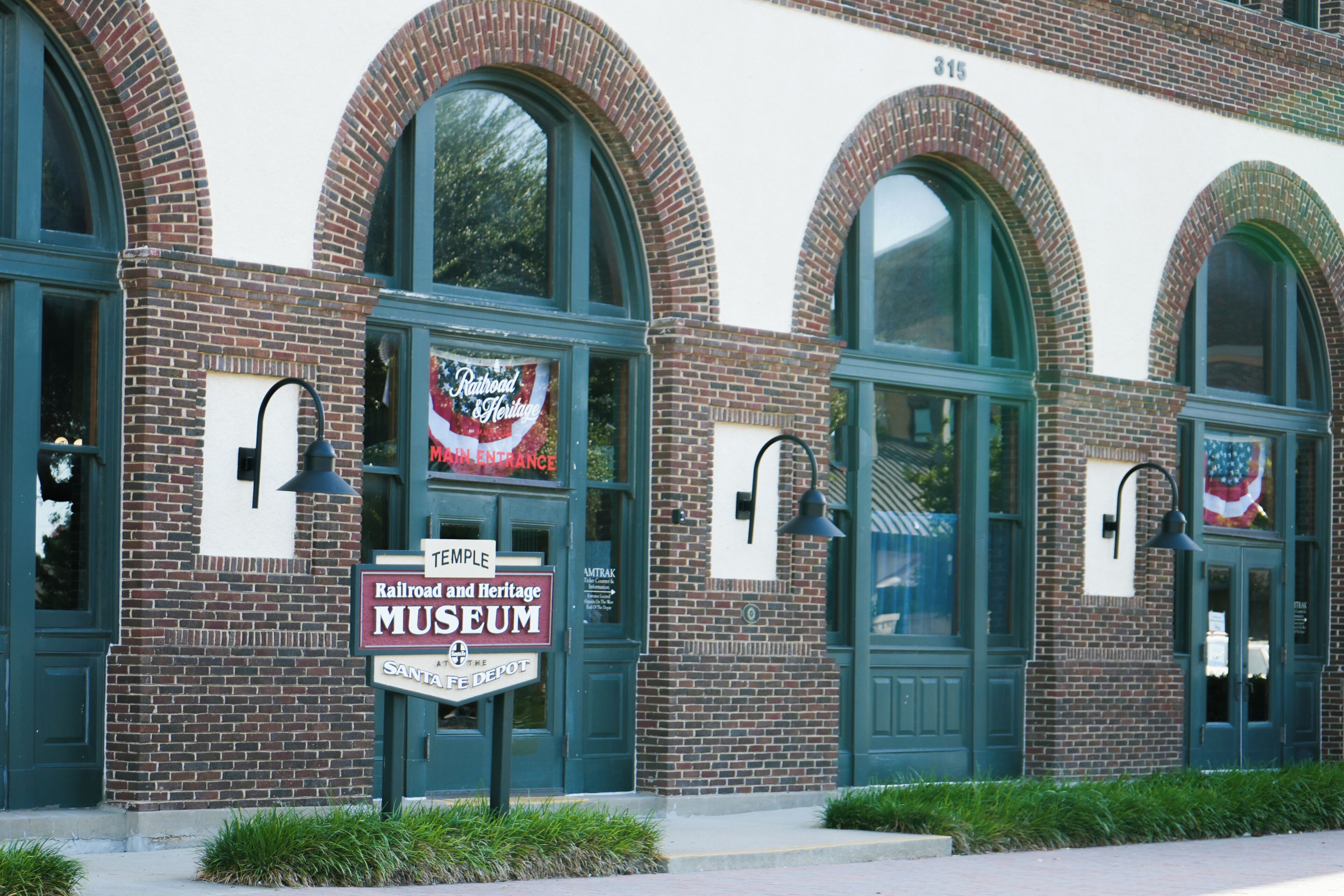 A brick building with arched windows and a sign for the Railroad and Heritage Museum.