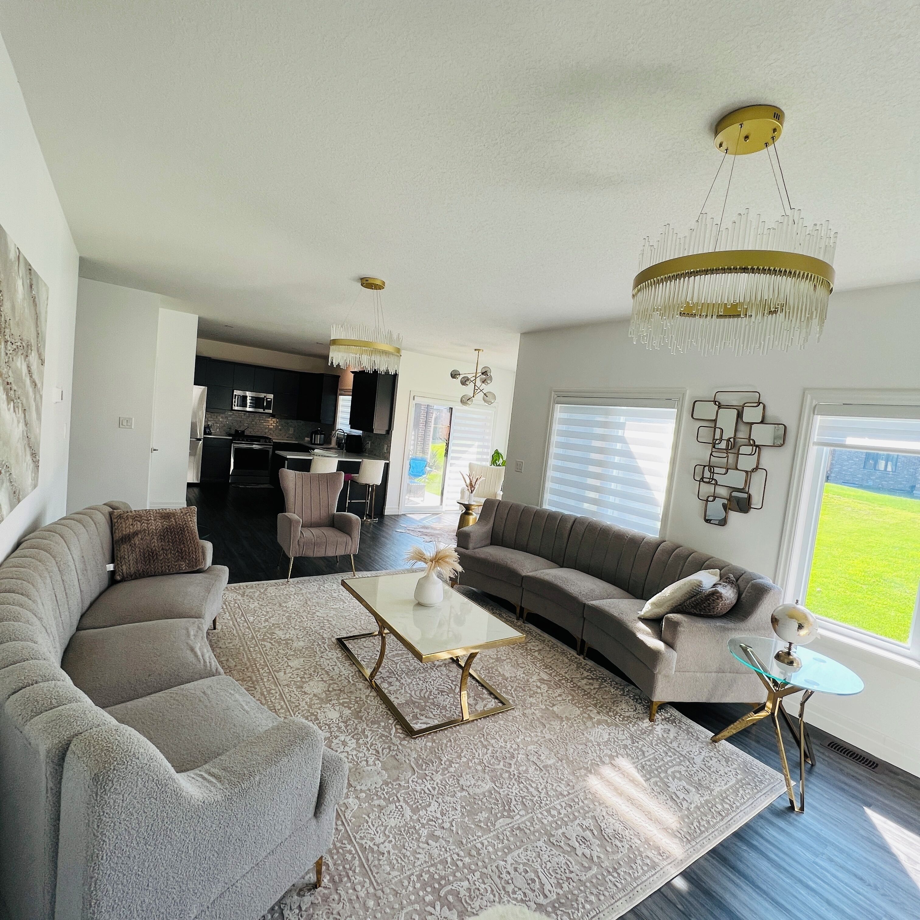 A modern living room with a sectional sofa, a coffee table, and a dining area in the background.