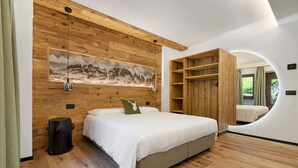 Een slaapkamer met een bed, houten wandbekleding, een hangend kunstwerk en een inbouwkast.