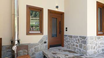 A stone bench, a door, and a window with a view of a landscape.