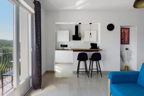 Une cuisine moderne avec un coin repas, une grande fenêtre et une vue sur l’extérieur.