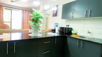 Una cocina moderna con armarios oscuros, una isla central y un comedor con vistas.