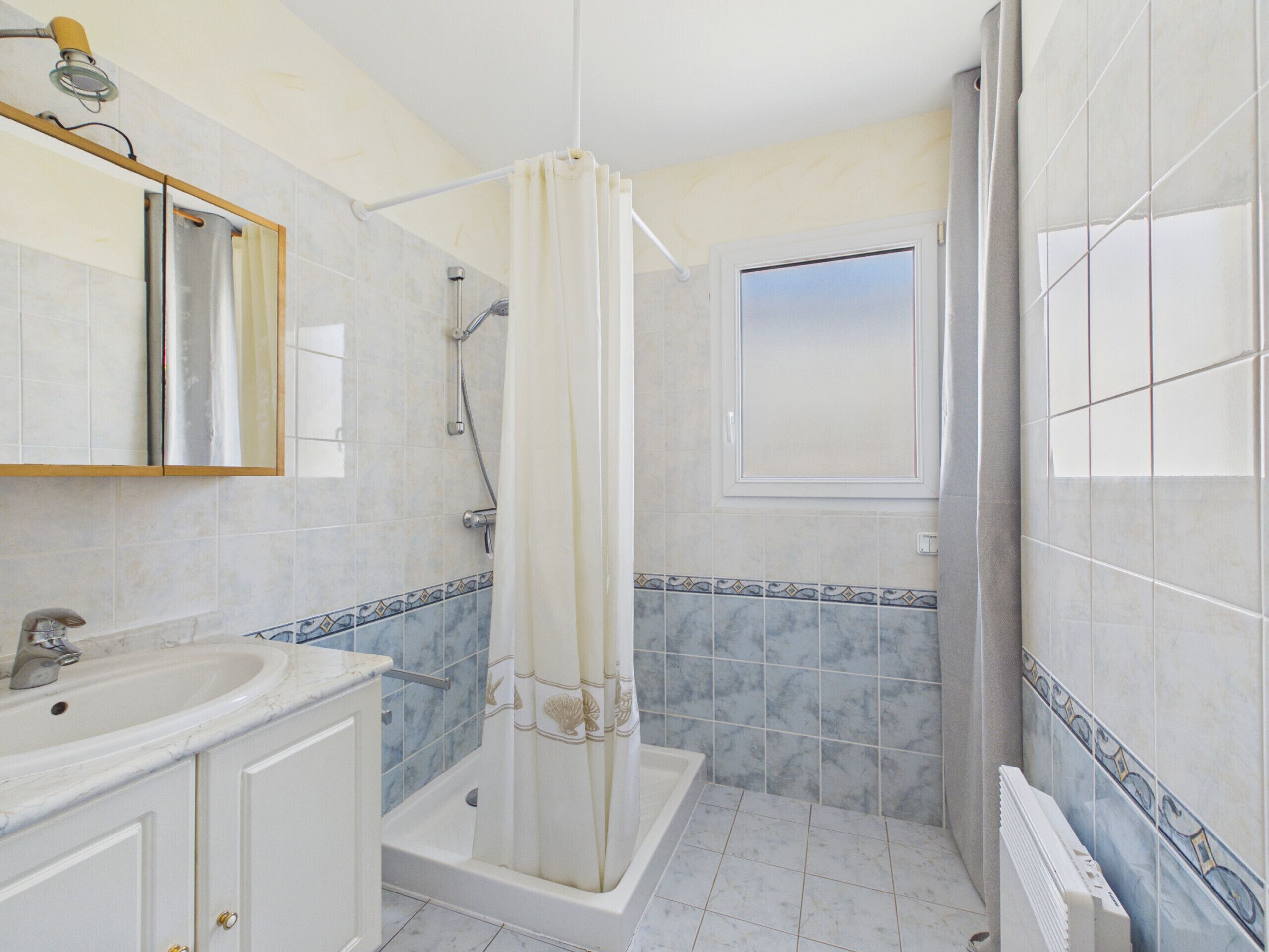 Un baño con bañera, ducha, lavabo y espejo.