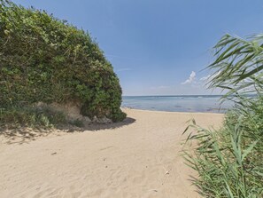 A sandy beach with vegetation on the left and a clear view of the ocean. - House and garden for 3 near the beach (La Plaine-sur-Mer)
