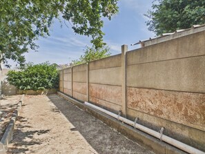A concrete wall with a drainage system, surrounded by greenery and a clear sky. - House and garden for 3 near the beach (La Plaine-sur-Mer)