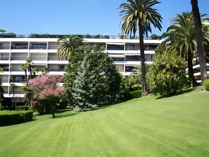 Um campo de golfe bem cuidado, com um edifício ao fundo.