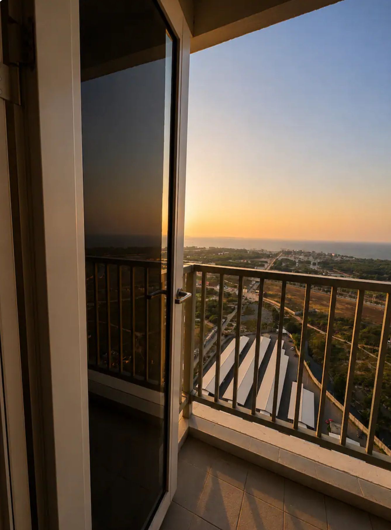Uma varanda com vista para a cidade ao pôr do sol.