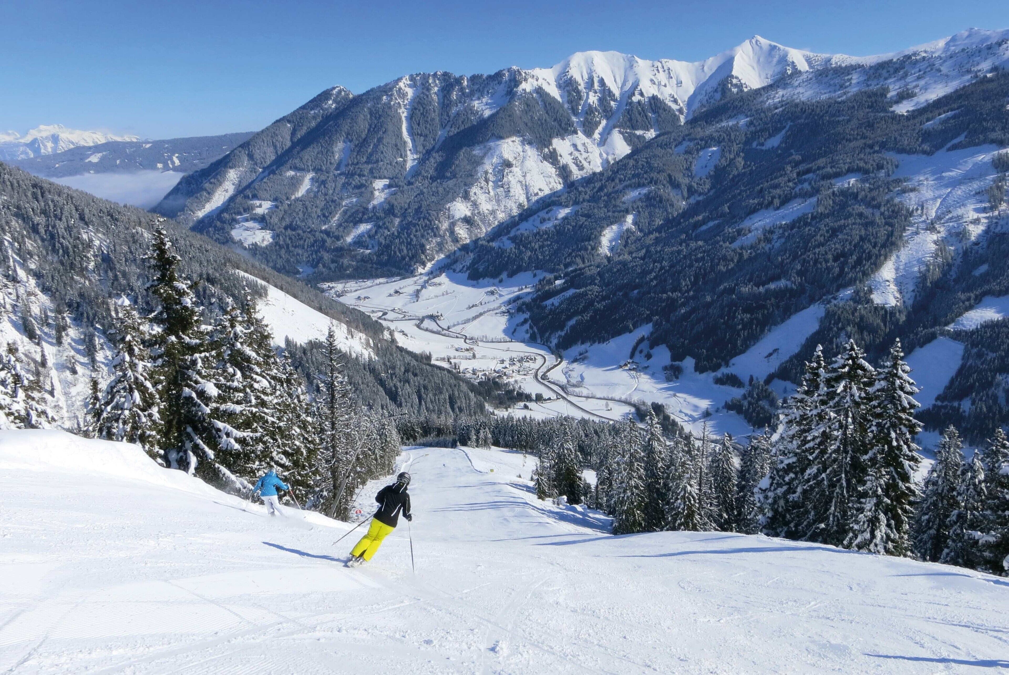 A snowy mountain landscape with skiers.