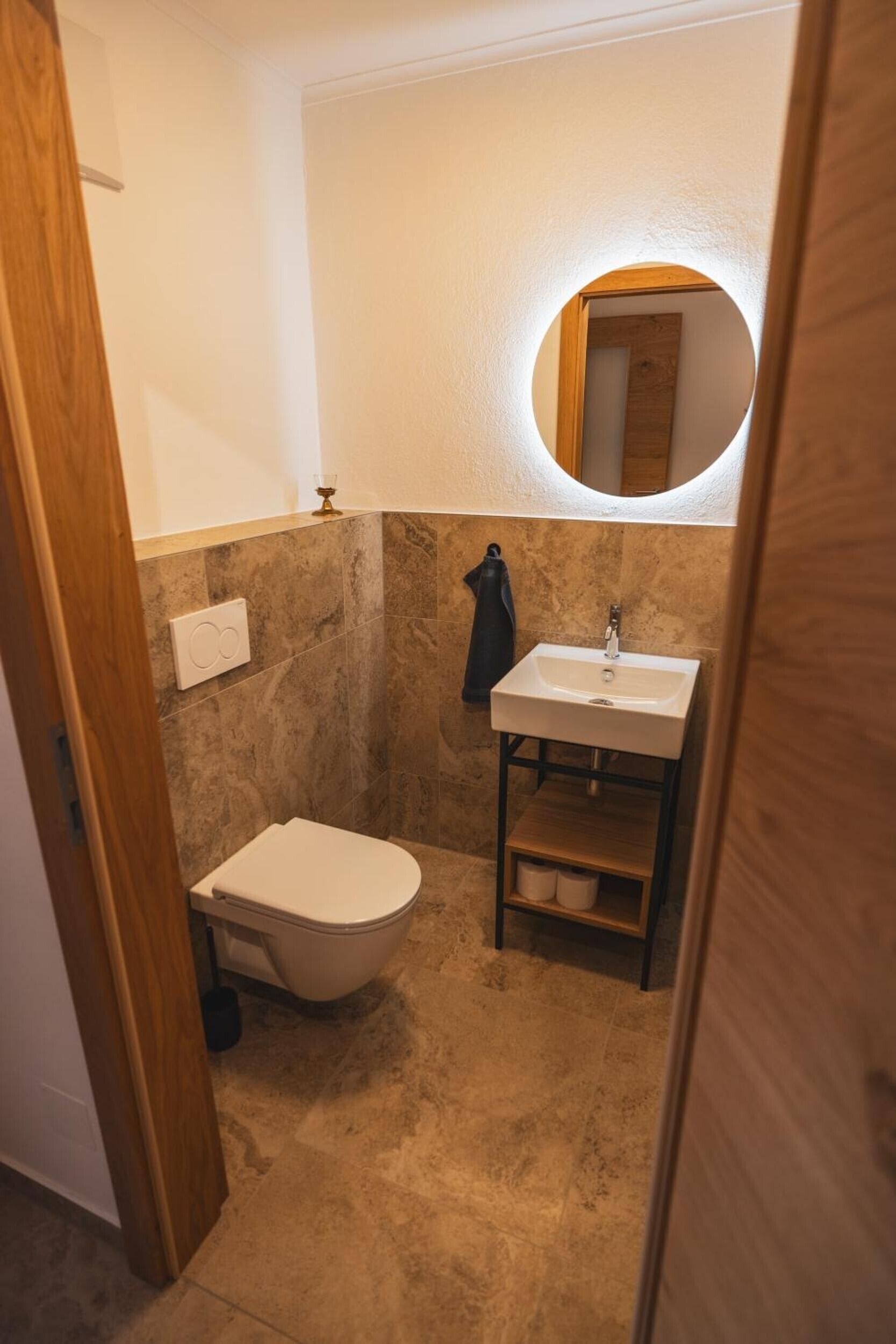 A compact bathroom with a toilet, sink, and a mirror.