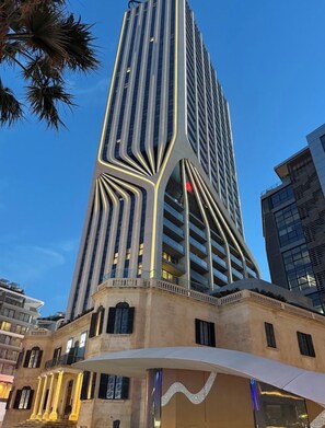 A modern high-rise building with a unique architectural design, featuring a series of vertical lines and a curved structure at the base. - Luxury 26th Floor Apartment with Panoramic Sea Views Mercury Towers St Julian (St. Julian's)