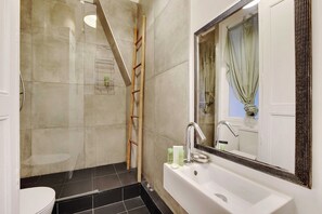 Ein Badezimmer mit Badewanne, Toilette und Duschbereich.