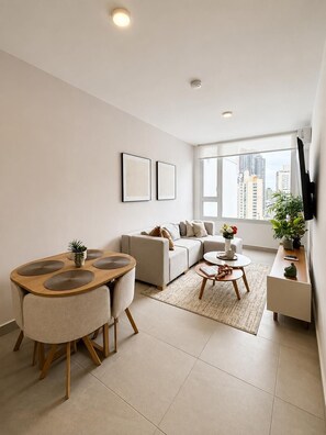 A modern living room with a sofa, coffee table, and dining area. - Charming 2BR + 2BA in Panama City's most luxurious building ✨🏙️🏊 (El Cangrejo)