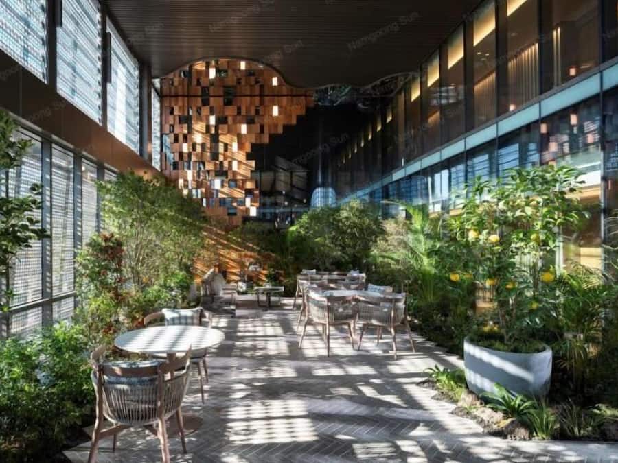 An indoor garden with seating, a patterned ceiling, and a view of the outside.