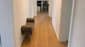 Un pasillo con suelo de madera que conduce a una zona de cocina.