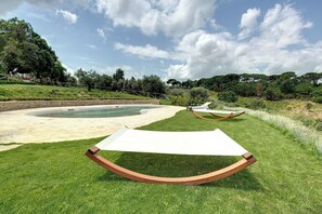 A grassy area with a pool and a hammock. - LOFT PIAZZALE MICHELANGELO (Toscana)