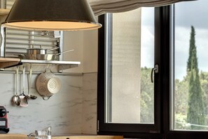 A kitchen with a hanging colander, a pot, and a stove. - LOFT PIAZZALE MICHELANGELO (Toscana)