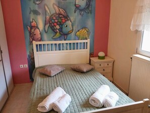 A bedroom with a bed, pillows, a nightstand, and a wall mural. - Villa Marilena at Nafpaktos. (Paleopanagia)