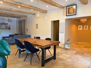 A dining area with a wooden table, blue chairs, and a globe centerpiece. - Family Home in Provence (Piolenc)