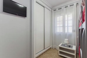 A bathroom with a white tiled floor, a white vanity with a mirror, a towel rack, and a shower curtain. - Apartment with Ocean Views in Fuentebravía Beach (EL PUERTO DE SANTA MARIA)