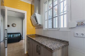 Une cuisine dotée d’un plan de travail en granit, de meubles blancs, d’un four encastré et d’une fenêtre offrant une vue agréable.