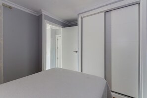 A room with a bed, a wardrobe, and a door leading to another room. - Apartment with Ocean Views in Fuentebravía Beach (EL PUERTO DE SANTA MARIA)