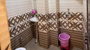 Ein Badezimmer mit Toilette, Waschbecken, Dusche und Warmwasserbereiter.