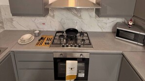 Una cocina moderna con estufa a gas, microondas y horno empotrado.
