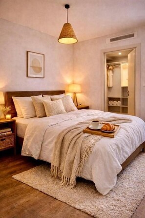 Ein Schlafzimmer mit einem großen Bett, Nachttischlampen, einer Hängeleuchte und einem Holznachttisch.