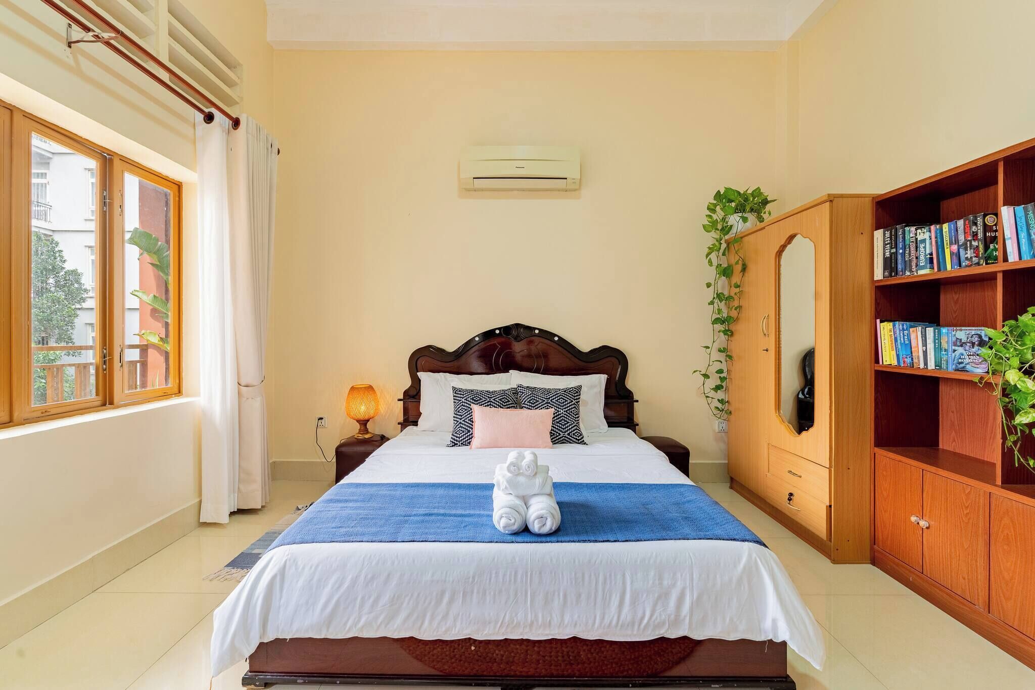 A bedroom with a bed, bedside lamp, and a bookshelf.