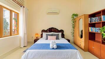 A bedroom with a bed, bedside lamp, and a bookshelf.