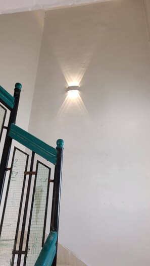 Una escalera con barandilla y un accesorio de iluminación en la parte superior.