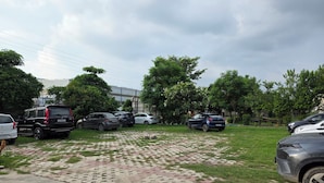 A parking lot with multiple cars and a building in the background. - Spacious & Cozy 2BHK Retreat , Pet-Friendly , Near SIDCUL & Har Ki Pauri (Salempur Mahdood)