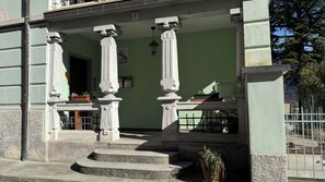 A building with a green facade, a set of stairs leading to a balcony, and a metal fence in the background. - La Casa del Re, just 400 meters from Lake Idro (Anfo)
