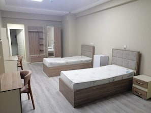 A bedroom with two beds, a desk, and a wardrobe. - Vigo Care (Baku)
