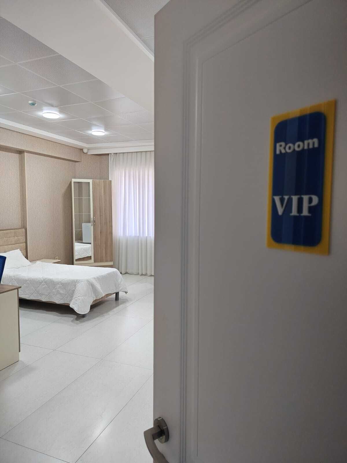 Una habitación de hotel con una cama, un armario, un espejo y un cartel que indica que es una habitación VIP.