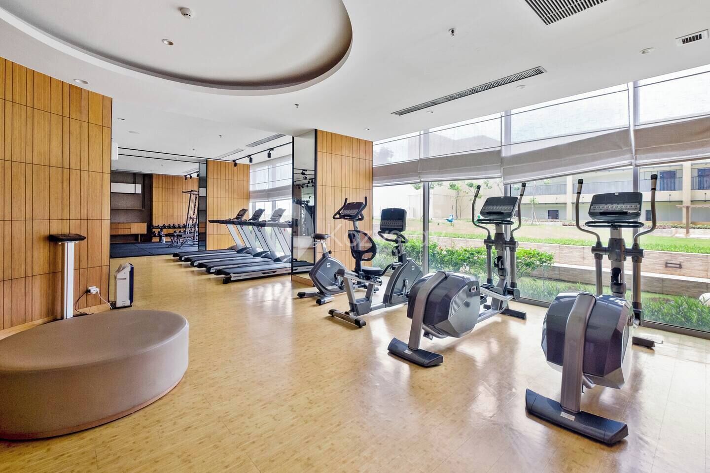 Un gimnasio moderno con cintas de correr, elípticas y una máquina de remo.