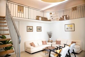 A living room with a sofa set, a coffee table, and a staircase. - House Domusella Apartment, in the heart of Rome—quiet and comfortable (Roma)