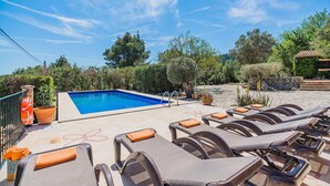 A pool area with lounge chairs and a lifebuoy. - Villa Near Pollensa Old Town (Pollença)