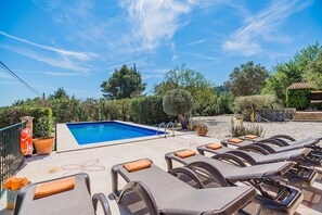 A pool area with lounge chairs and a lifebuoy. - Villa Near Pollensa Old Town (Pollença)