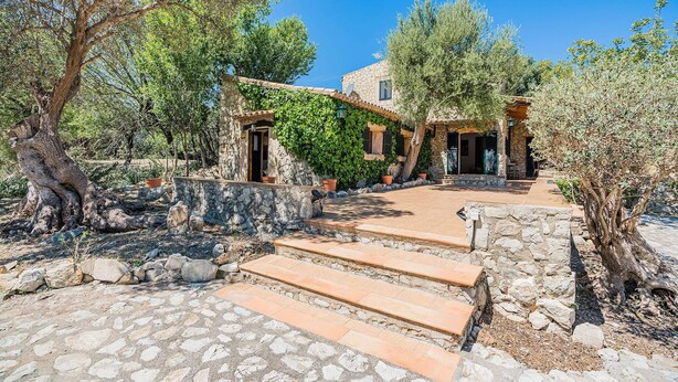 A stone building with a stone staircase leading to a door, surrounded by olive trees and a clear blue sky. - Villa Near Pollensa Old Town (Pollença)