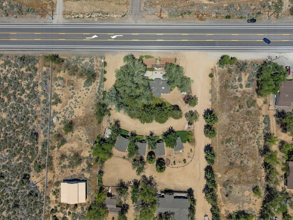 An aerial view of a residential area with a road, houses, and a large green park. - Sierra Retreat Motel (Coleville)