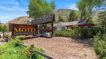 A Sierra Retreat Motel sign with a wooden structure and a red building in the background.