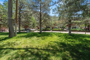 A park-like setting with trees, a small building, and a pathway. - Sierra Retreat Motel (Coleville)