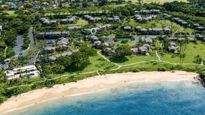 An aerial view of a coastal resort with multiple bungalow-style accommodations, a sandy beach, and a clear blue ocean. - Wailea Elua 1104 - Ocean Views, Central A/C, Walk to Ulua Beach, Shops & Dining! (Kihei)